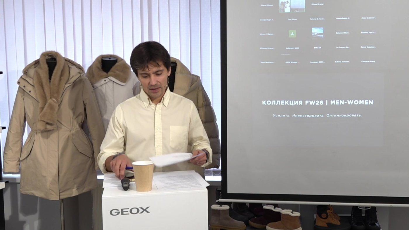 Спикер тренинга GEOX у стойки с презентацией на экране — кадр из трансляции Pro-Stream